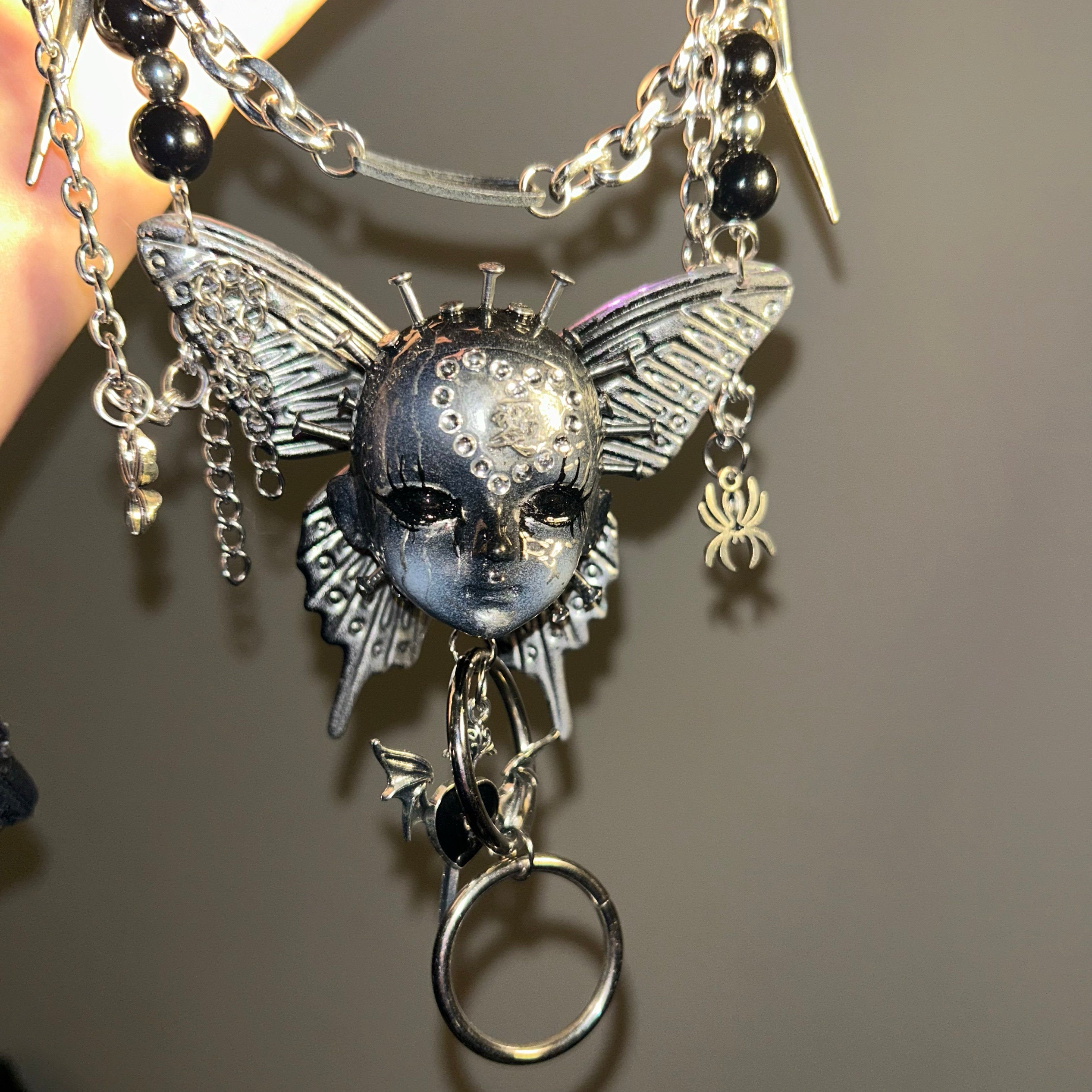 Silver Metallic Butterfly Doll Face Necklace with Rhinestone Heart & Winged Skull Charm