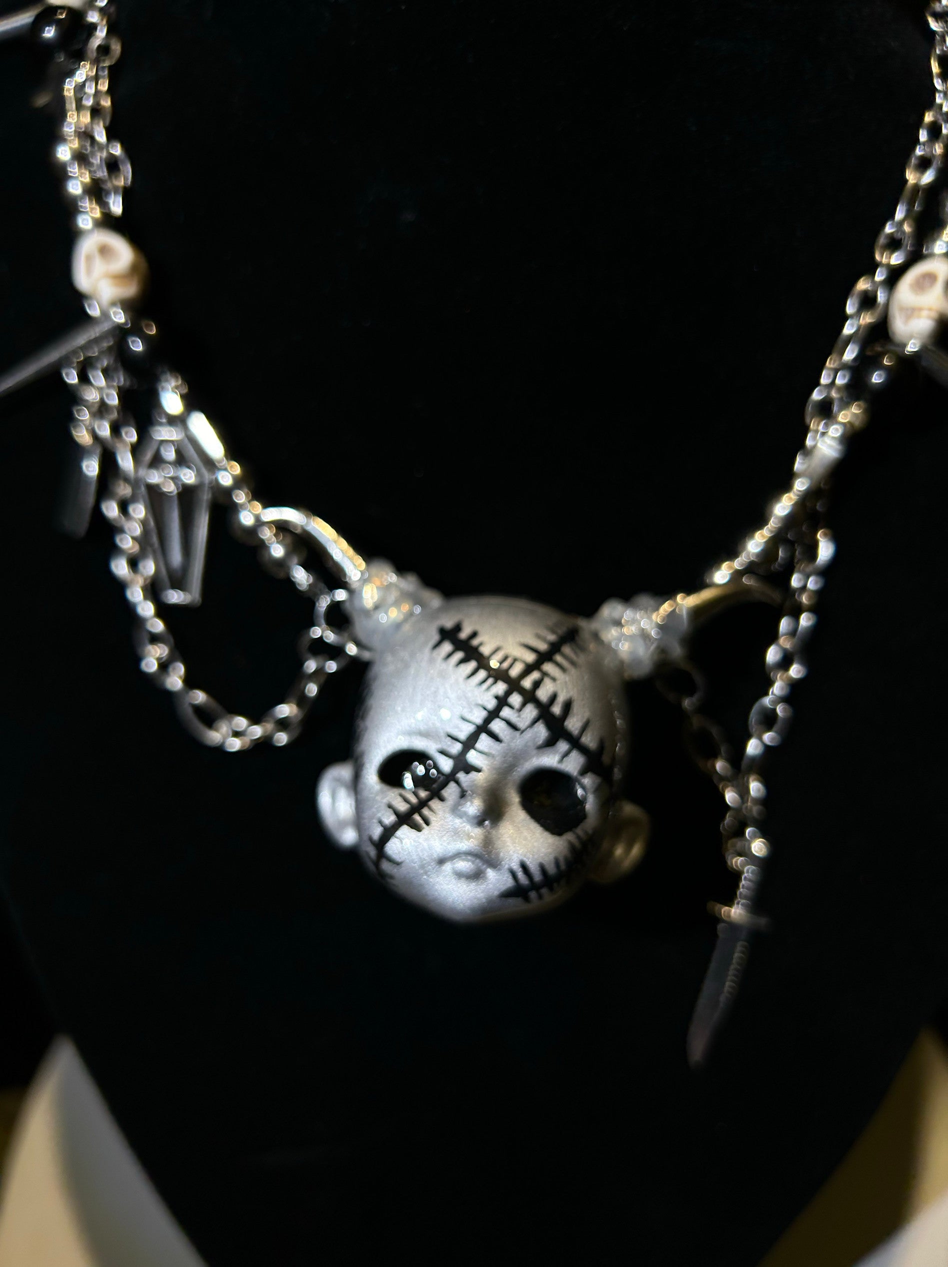 Silver Horned Stitched Doll Face Necklace with Cleaver, Knife & Coffin Charms