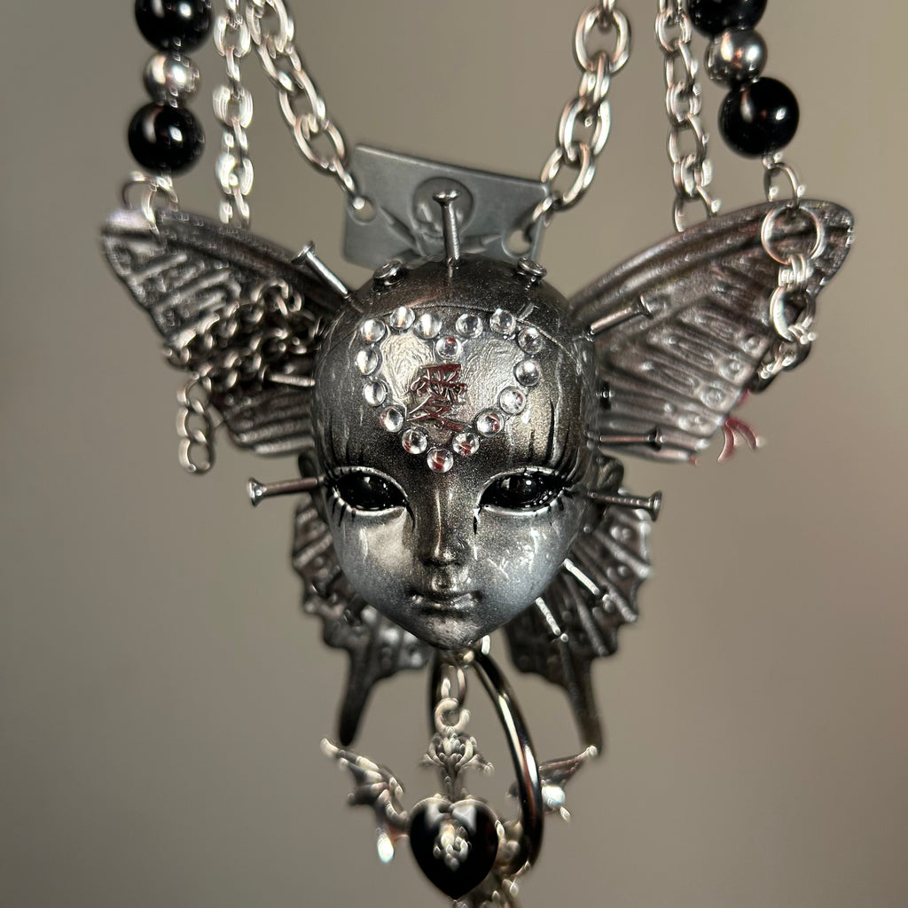 Silver Metallic Butterfly Doll Face Necklace with Rhinestone Heart & Winged Skull Charm