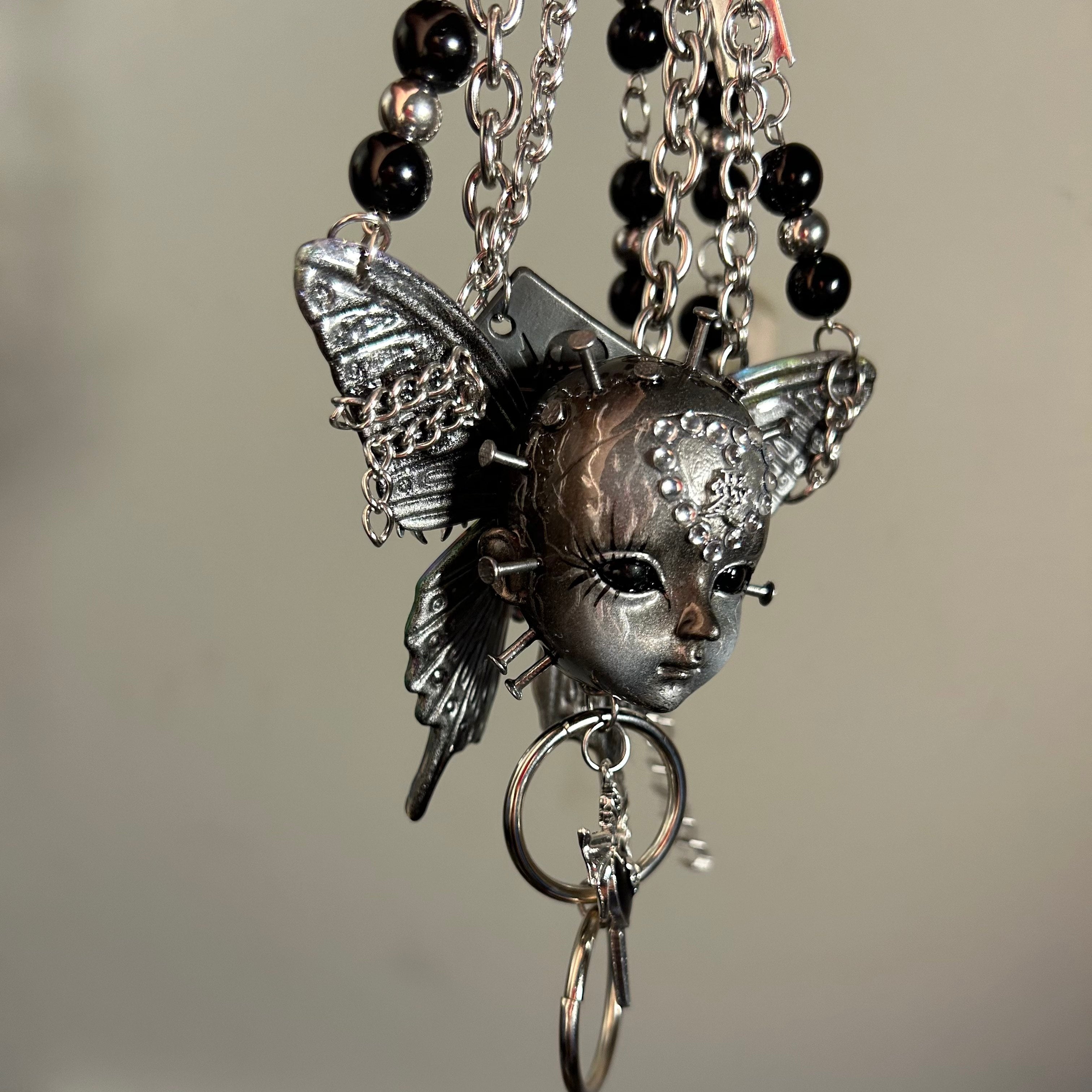 Silver Metallic Butterfly Doll Face Necklace with Rhinestone Heart & Winged Skull Charm
