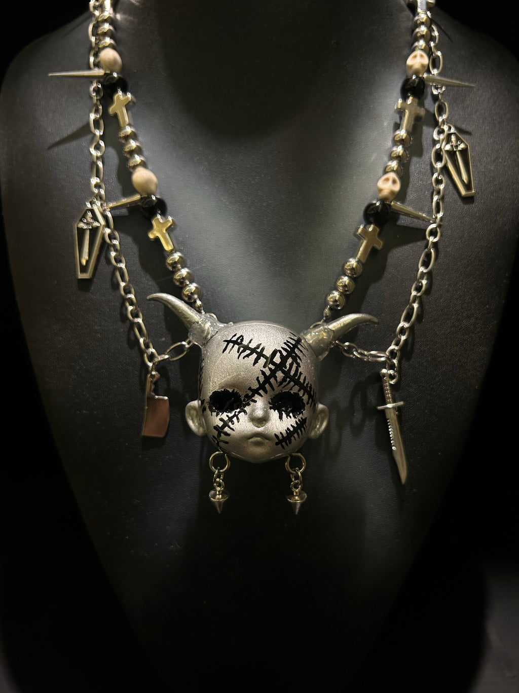 Silver Horned Stitched Doll Face Necklace with Cleaver, Knife & Coffin Charms