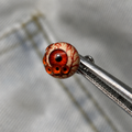 Red Thousandfold Omen multi-eye piercing top held in tweezers