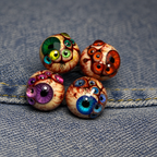 Four colorful Thousandfold Omen multi-eye piercing tops on denim